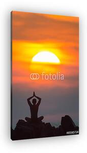Yoga. A sziluettje a férfi meditál a sziklákon a szabadban. (vászonkép)