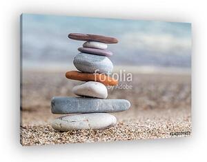 Pile of stacked stones on the sandy beach at Adriatic sea (vászonkép)