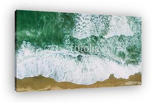 Waves near beach. Yellow sand and green water (vászonkép)