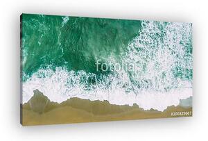 Waves near beach. Yellow sand and green water (vászonkép)
