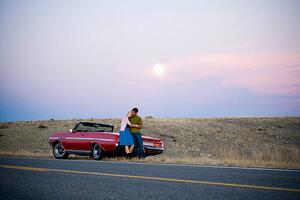 Művészeti fotózás man and woman next to a red convertible, Mike Kemp, (40 x 26.7 cm)