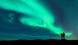 Fotográfia Aurora borealis and silhouette of man and woman, den-belitsky