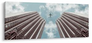 Repülőgép az épületek között képe (120x50 cm)