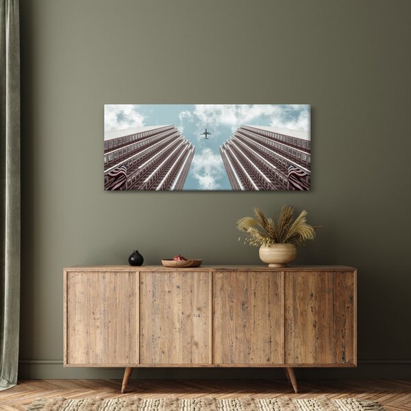 Repülőgép az épületek között képe (120x50 cm)