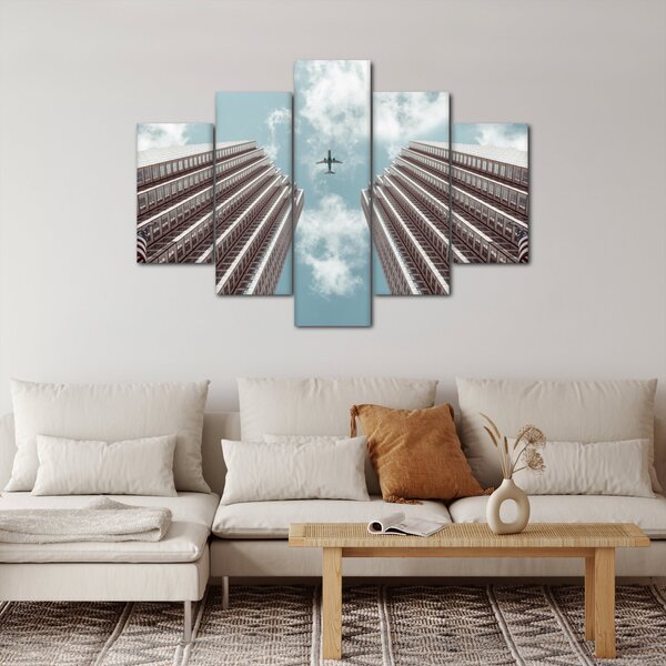 Repülőgép az épületek között képe (150x105 cm)