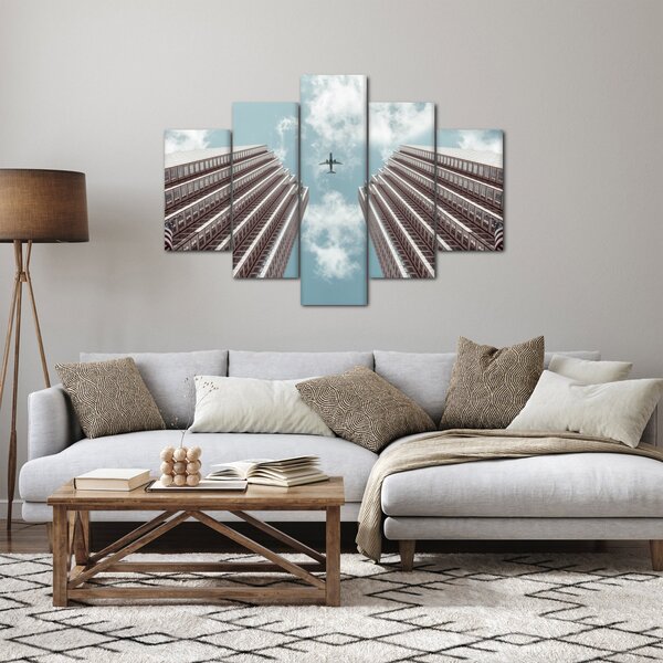 Repülőgép az épületek között képe (150x105 cm)