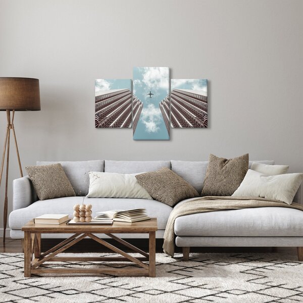 Repülőgép az épületek között képe (90x60 cm)