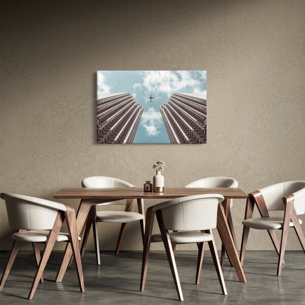 Repülőgép az épületek között képe (90x60 cm)