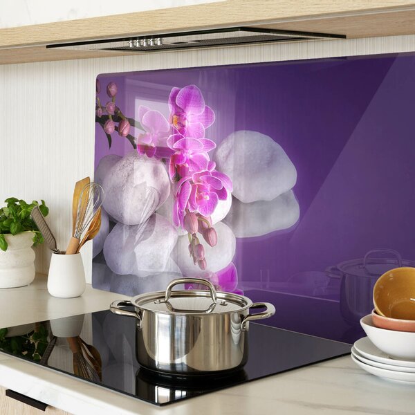 Üveg vágódeszka fényképpel Orchidea virágok kövek hátterében