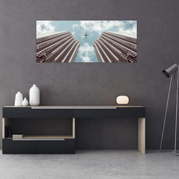 Repülőgép az épületek között képe (120x50 cm)