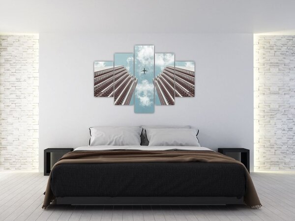 Repülőgép az épületek között képe (150x105 cm)